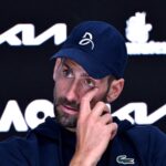 Primo piano di Djokovic in conferenza stampa che si asciuga una lacrima