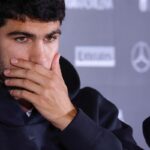 Carlos Alcaraz si porta la mano alla bocca in conferenza stampa