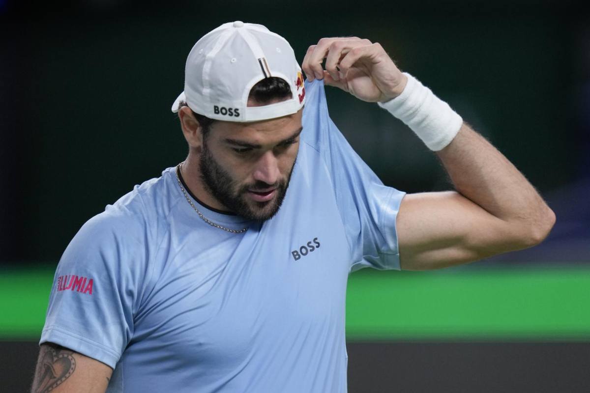 Matteo Berrettini pensieroso si tira su la maglia con una mano