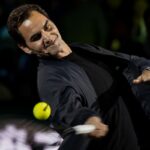 Roger Federer gioca a tennis con la giacca durante un evento di esibizione